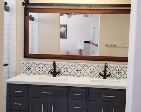 Bathroom vanity with patterned tile backsplash by Rocca Tile and Granite