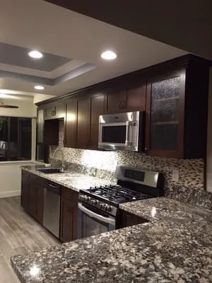 Espresso kitchen cabinets with mosaic tile backsplash installed by Rocca Tile