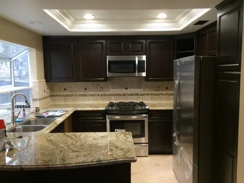 Kitchen with espresso cabinets and granite countertops by Rocca Tile