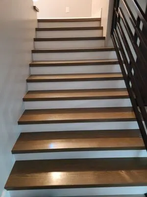 Staircase with wooden treads and metal balusters installed by Rocca Tile